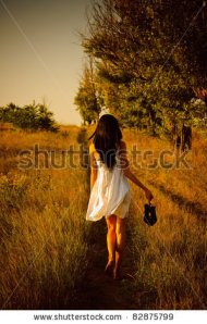 stock-photo-the-barefoot-girl-in-white-dress-with-shoes-in-hand-is-on-the-field-rear-view-82875799